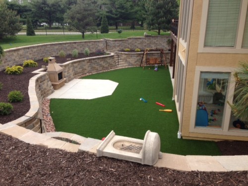 Family backyard with landscape turf and fireplace in Missouri