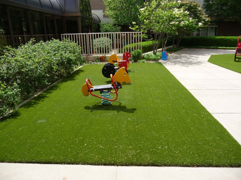 Spring riding horses on artificial playground turf in St. Louis