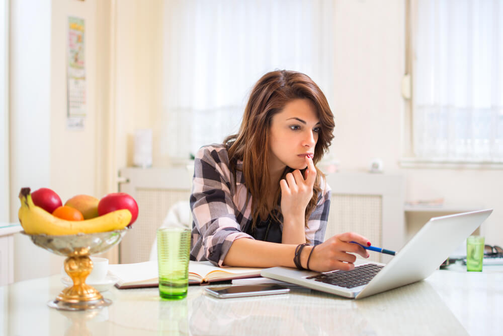 Woman on laptop in kitchen considering turf options
