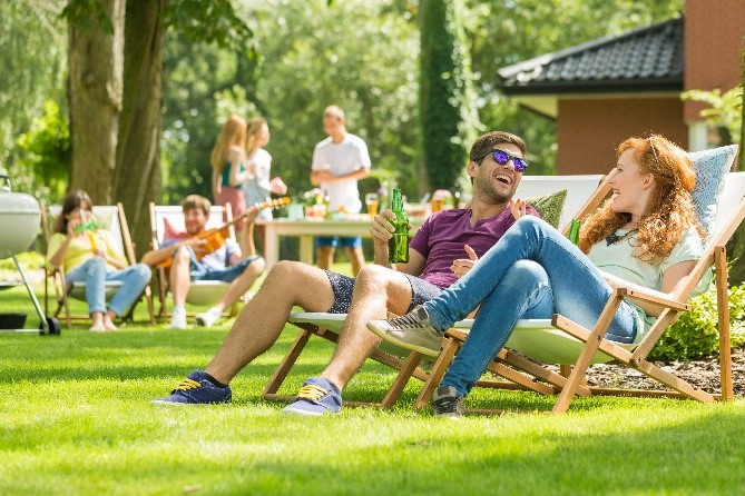 Two people sitting in lawn chairs relaxing on grass