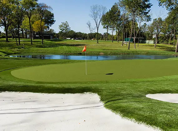 Waterfront artificial grass putting green with red flag